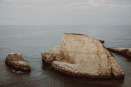 Cliffs in Ocean Water on Sunset