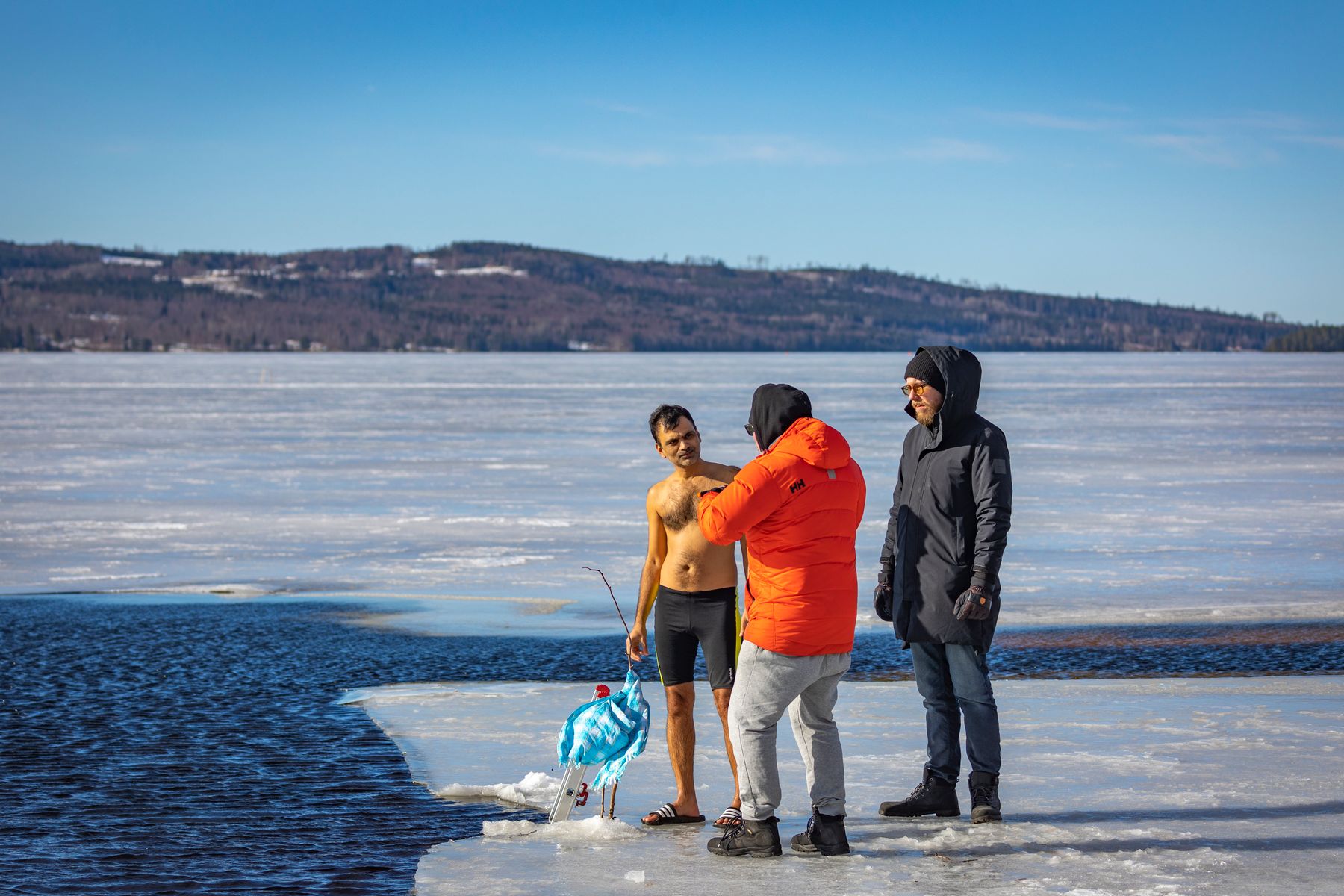 Petit groupe se préparant à une baignade hivernale sur un lac gelé