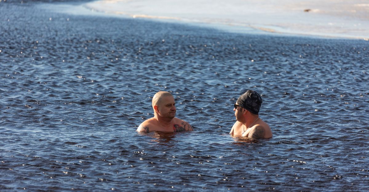 Swimmer in a wetsuit entering cold winter sea