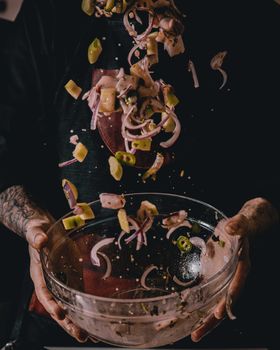 Explore the dynamic movement of a tossed salad, showcasing fresh ingredients in a chef's hands.