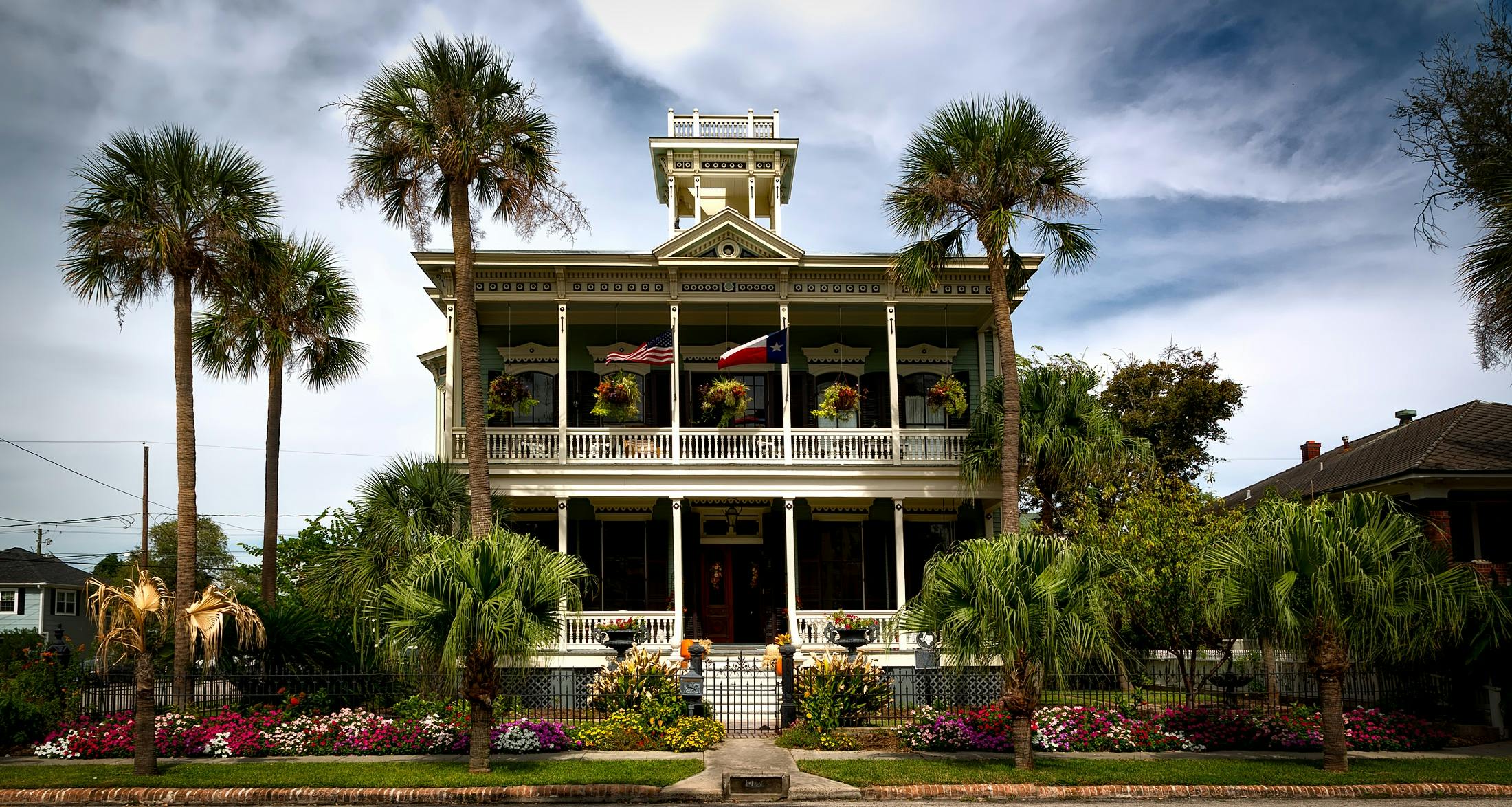 white painted structure with green palm trees in the front