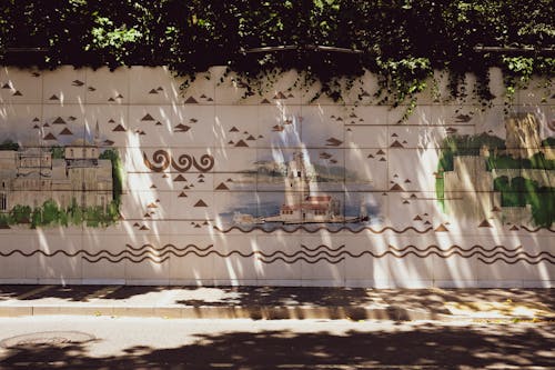 Murals of Istanbuls Landmarks on a Wall by a Street and under Trees