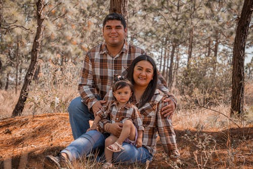 Mother, Father and Daughter Posing Together in Forest