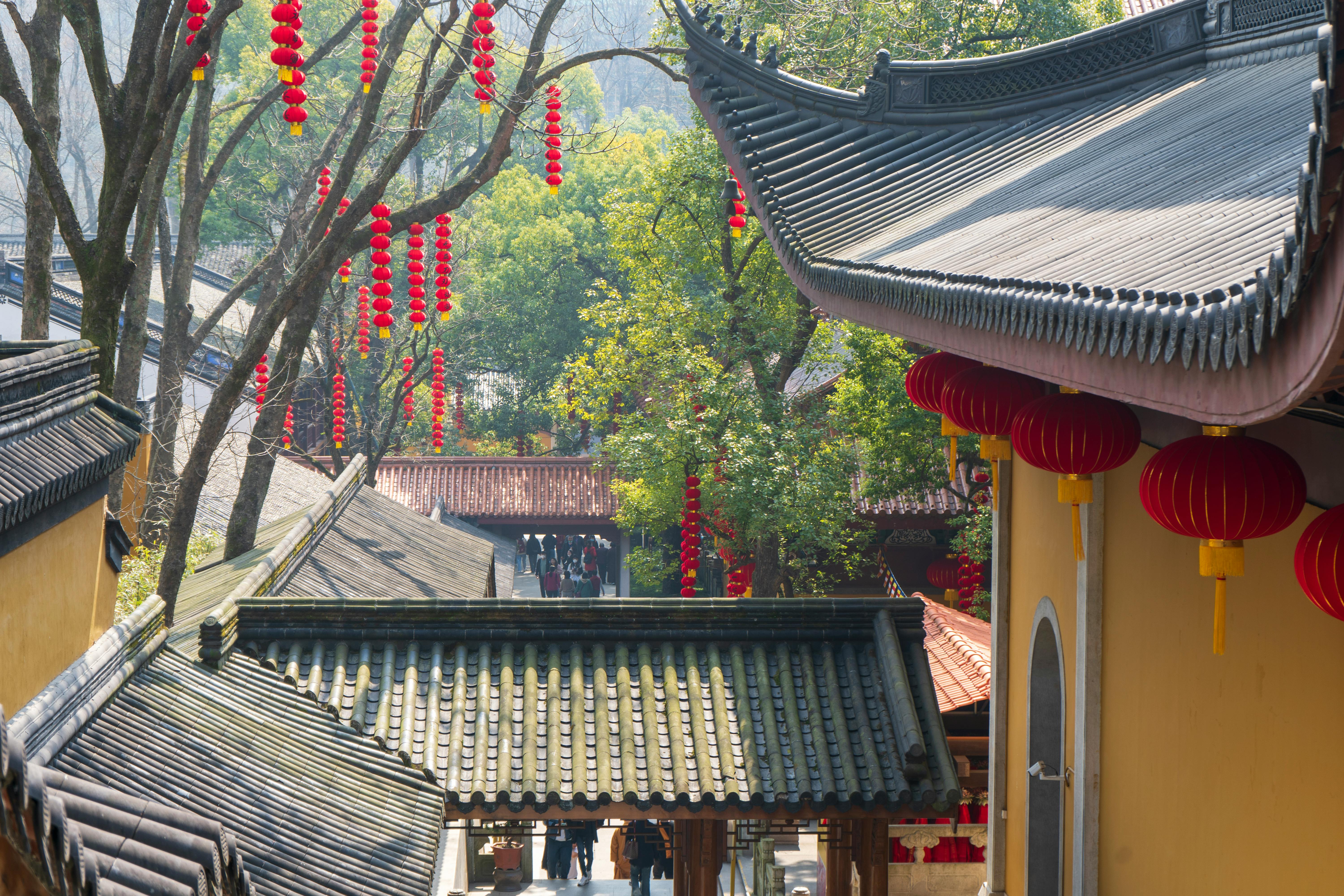 Peaceful Buddhist temple scene with red lanterns and traditional architecture.
