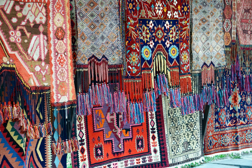Free Vibrant display of traditional handmade rugs at a market showcasing intricate patterns and craftsmanship. Stock Photo