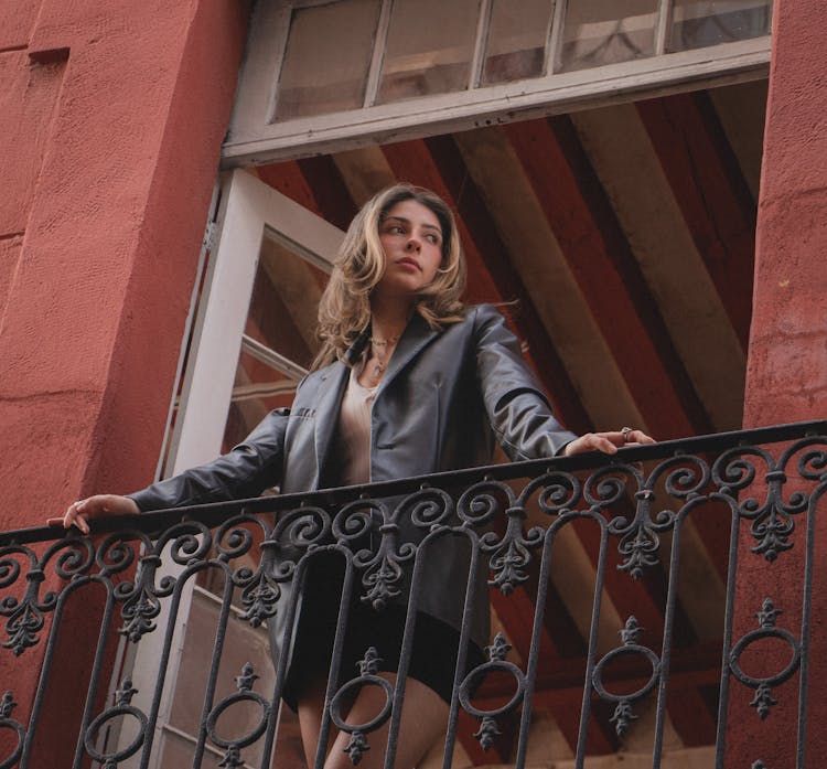 Young Woman In Leather Jacket And Mini Skirt On Balcony