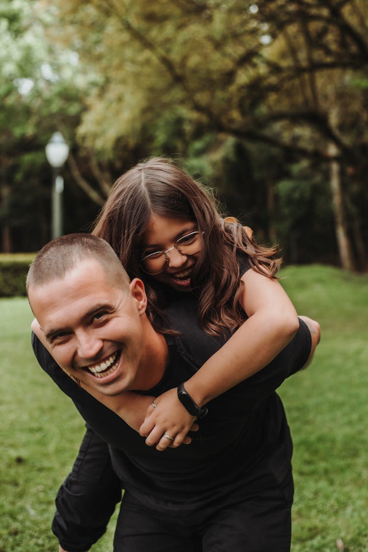 Man Carrying Girl On Back