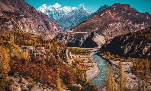 Free Breathtaking aerial view of a winding river in a mountain valley with vibrant autumn foliage. Stock Photo