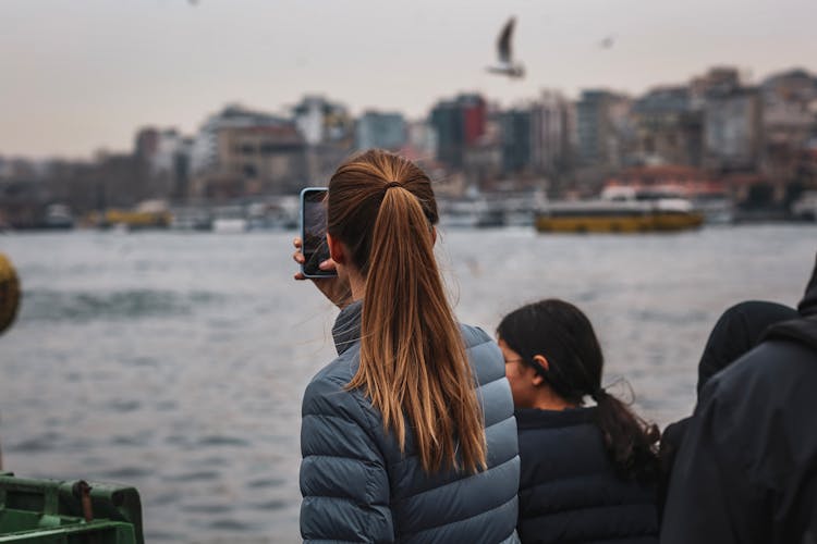 Girl Taking Picture With Cellphone In Harbor