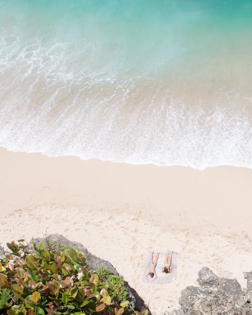 Ücretsiz Kumsalda Güneşlenirken İnsanların Fotoğrafı Stok Fotoğraflar
