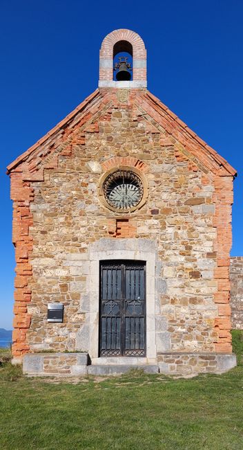Fotomural Un exterior de capilla de piedra vintage con una fachada rústica, ubicado en un sereno paisaje campestre.