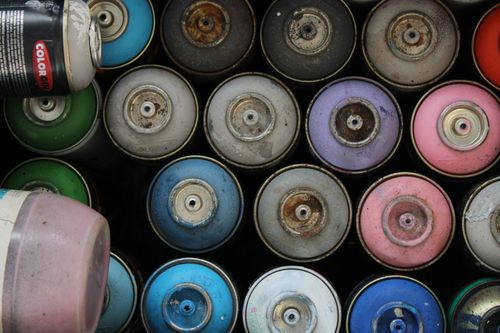Free Top view of various colorful and rusty spray paint cans in storage. Stock Photo