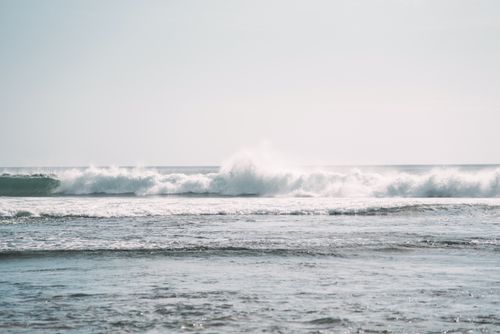 Free Captivating image of ocean waves crashing with white foam against a serene shoreline. Stock Photo