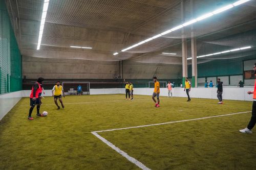 Free A friendly indoor soccer match with diverse players on an artificial turf field. Stock Photo