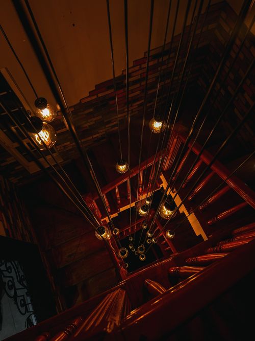 Free Top view of a lit staircase with hanging lamps in Ankara, creating a warm and artistic ambiance. Stock Photo