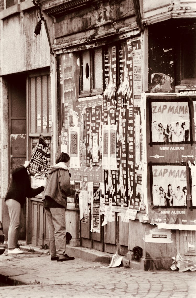 People Tearing Posters From Wall