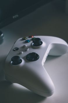 A detailed close-up of a sleek white wireless game controller on a desk.