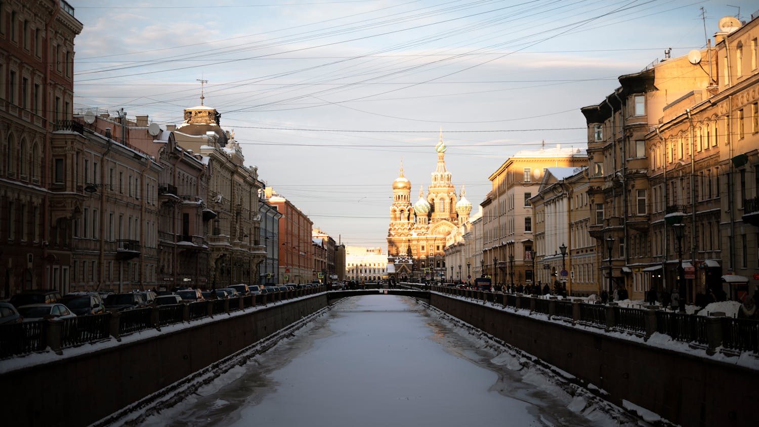 A winter scene of a frozen canal leading to a church in Saint Petersburg