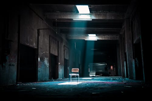 Krzesło W Opuszczonym Miejscu Z Reflektorem Pochodzącym Z Zewnątrz