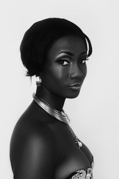 Stunning black and white studio portrait of a fashionable woman wearing a necklace.