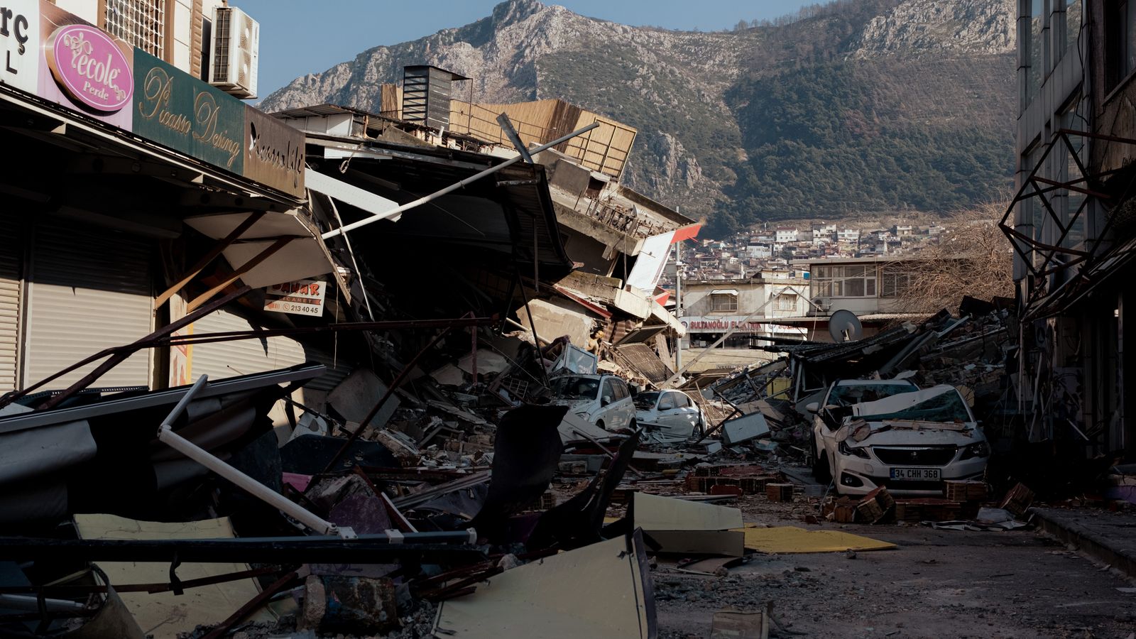 地震で倒壊した建物のがれきが広がる被災地の情景。企業の地震影響開示を検証する記事のイメージ。