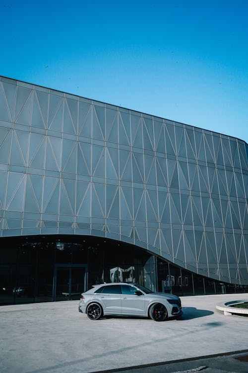 Gray Car in Front of Futuristic Building
