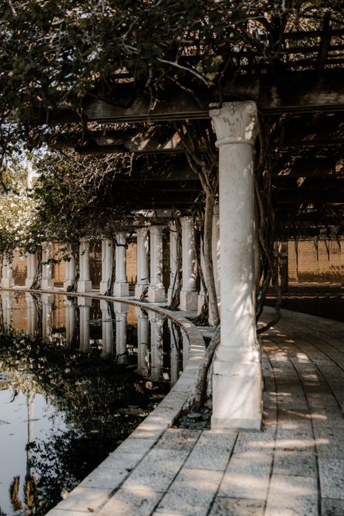 Free Tranquil view of columns and walkways reflected in a pond at a Miami park, evoking peace and serenity. Stock Photo