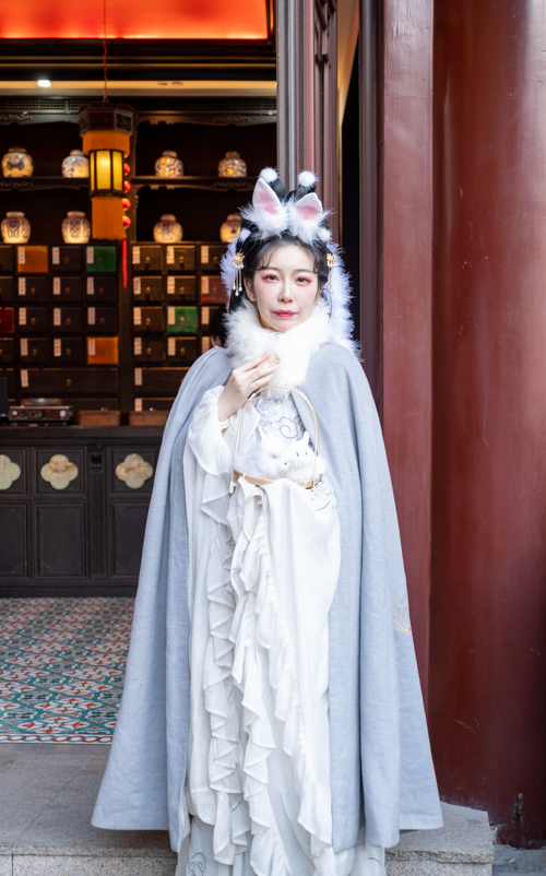 Free A woman in a white dress and cosplay costume stands in an elegant traditional setting. Stock Photo