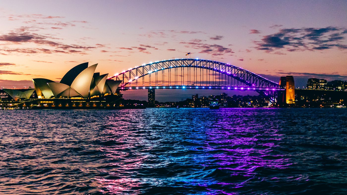 The Opera House and bridge lit against a deep evening sky