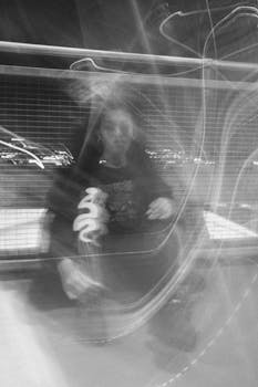 Artistic black and white portrait of a sitting woman with blurred motion in urban Birmingham.