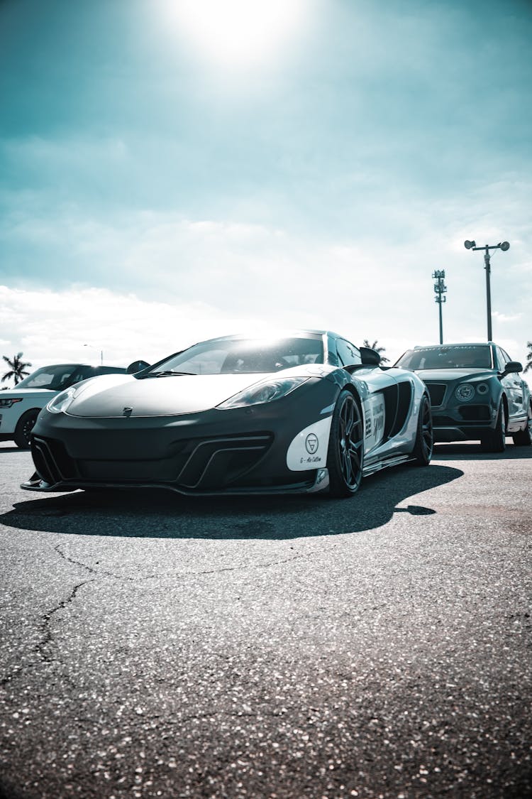 A Black And White Sports Car Parked In A Parking Lot