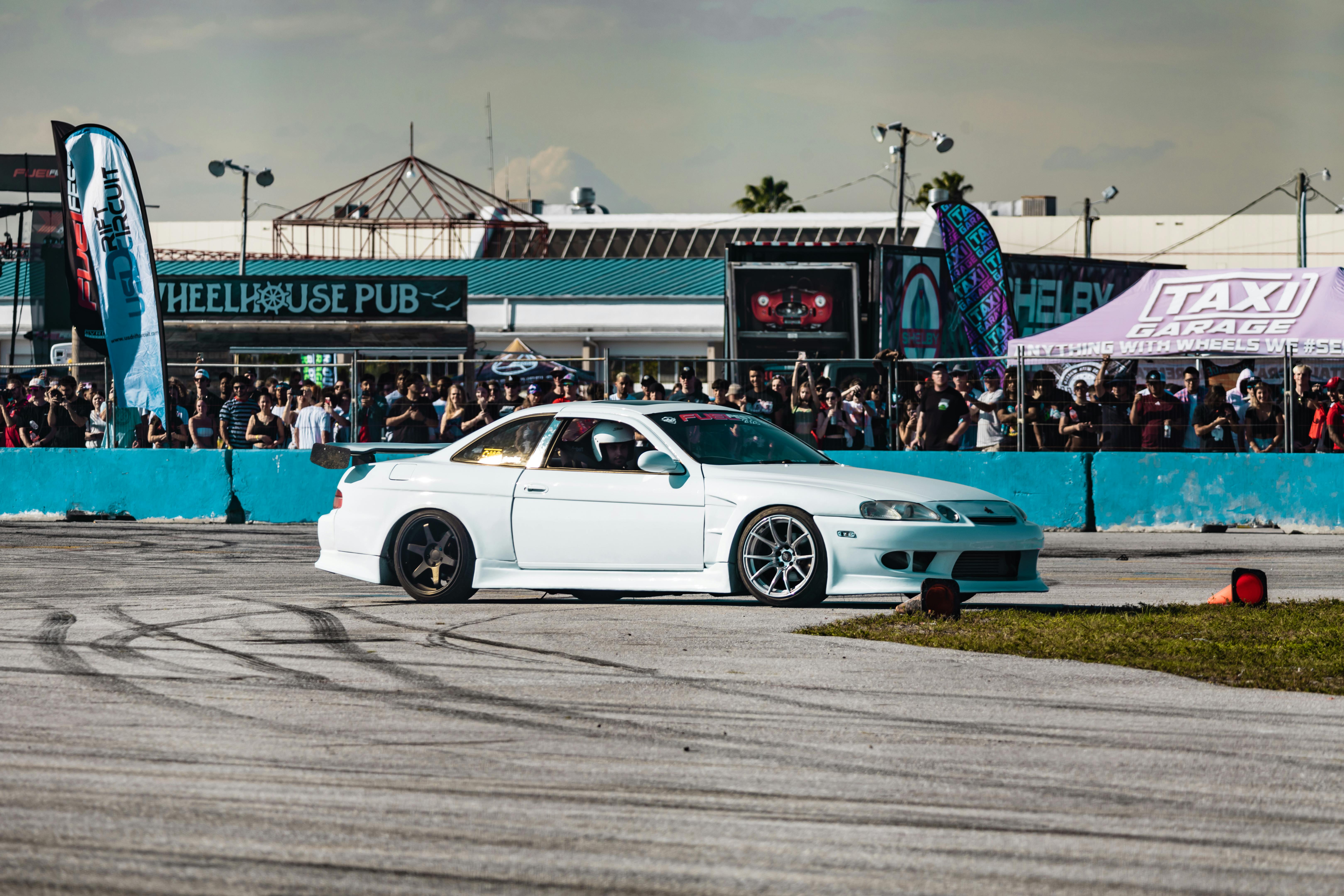 a white car is driving on a track