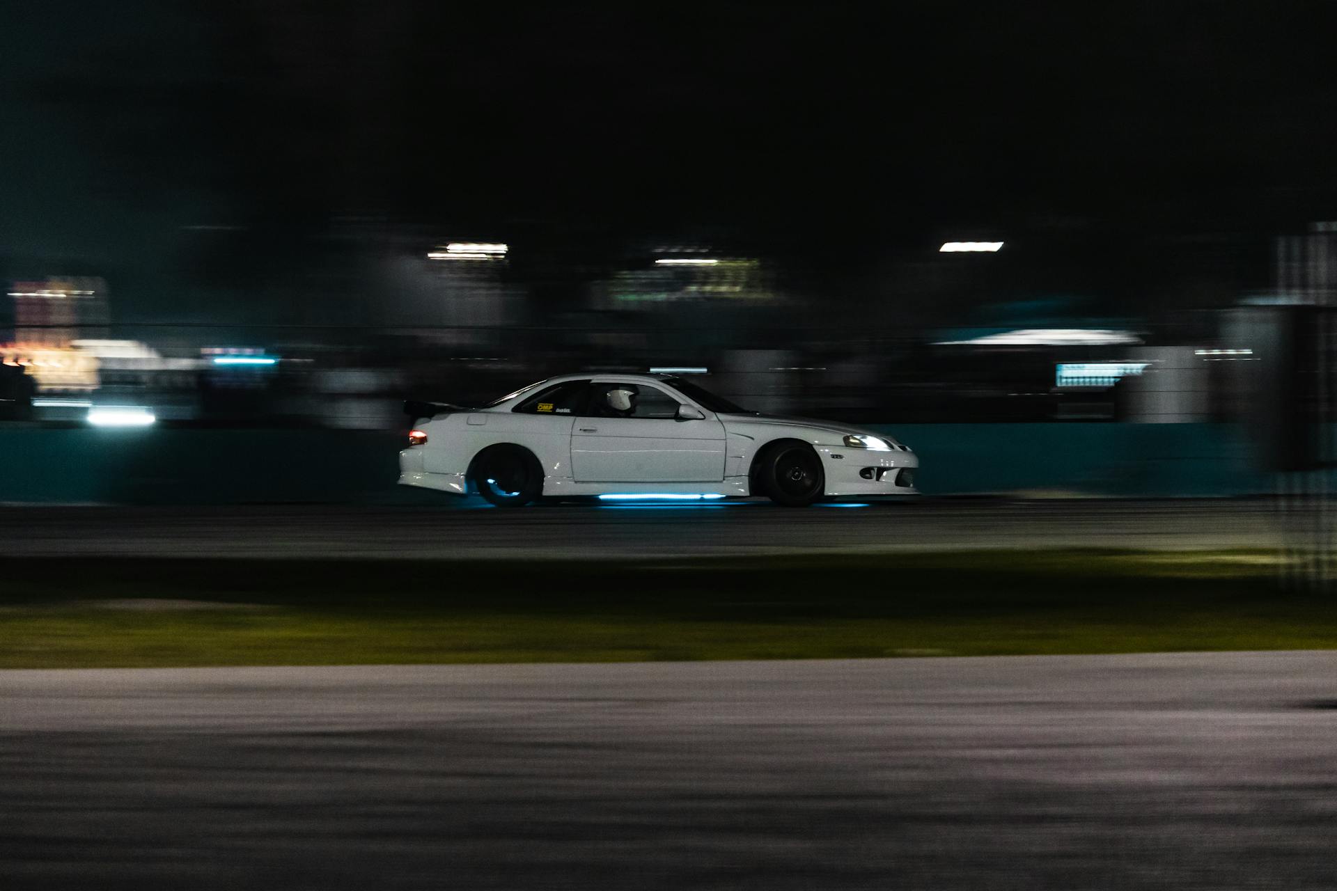 A white car driving on the track at night