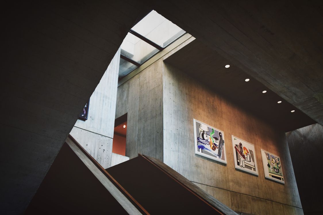 kenson Investments | Cybersecurity Firms Ramp Up Crypto Defenses as On-Chain Threats Evolve Interior of a modern art gallery with several paintings displayed on a concrete wall.