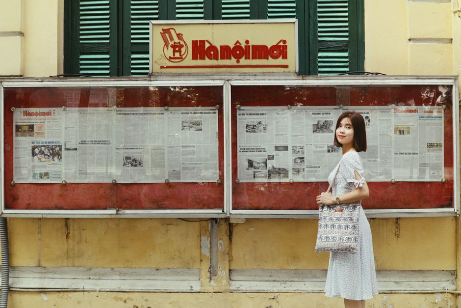 Tourist wearing a cross-body bag securely in the crowded Old Quarter of Hanoi, Vietnam