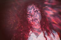 这幅描绘一位沉浸在光影艺术中的女性的肖像引人入胜，唤起了梦幻般的氛围