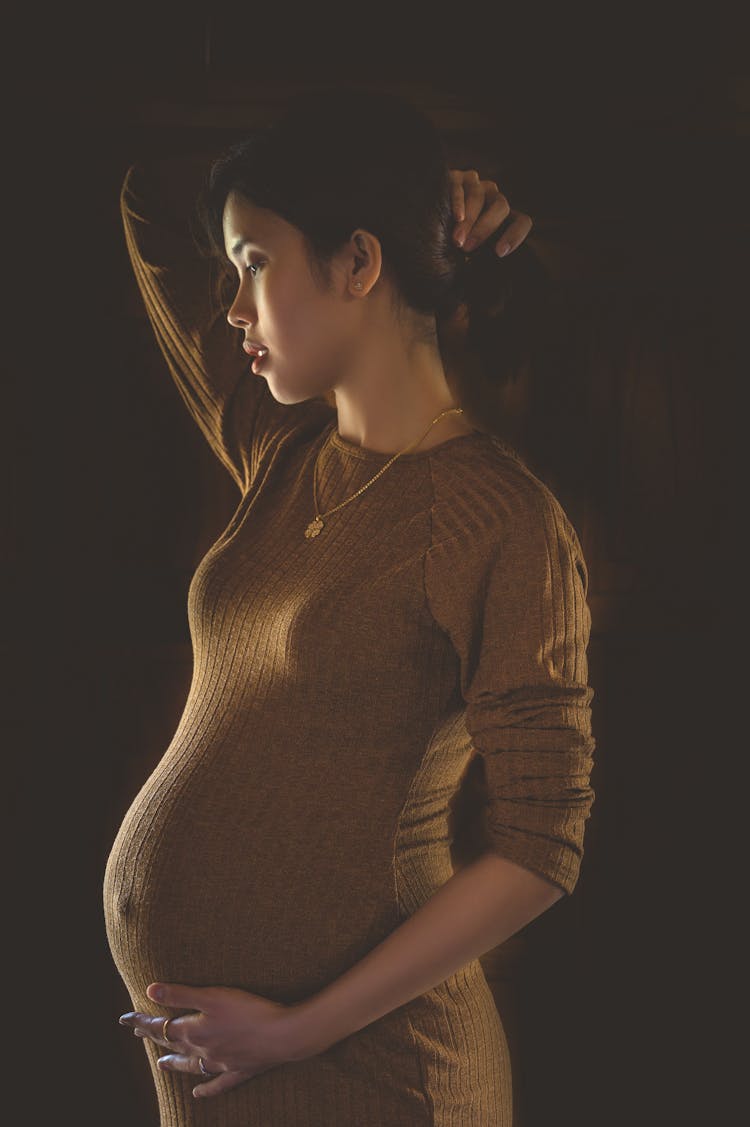 Pregnant Woman Wearing Tight Dress On Black Bac