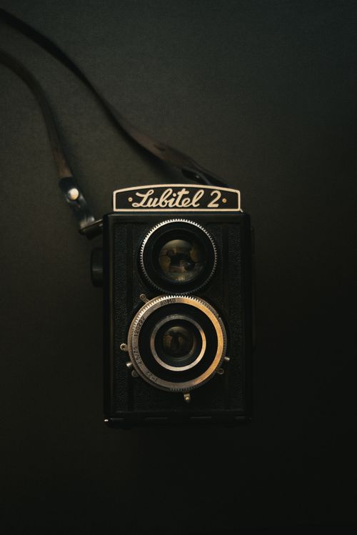 Free A classic Lubitel 2 camera captured in a moody, vintage style on a black background. Stock Photo