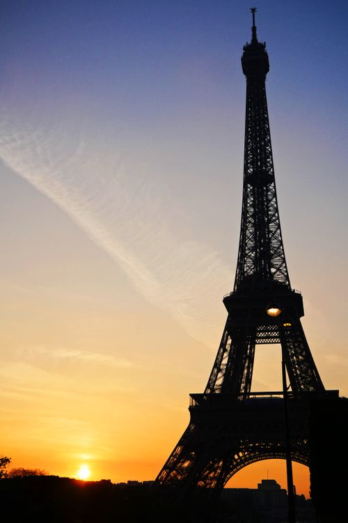 Free The iconic Eiffel Tower silhouetted against a vibrant Parisian sunset sky. Stock Photo