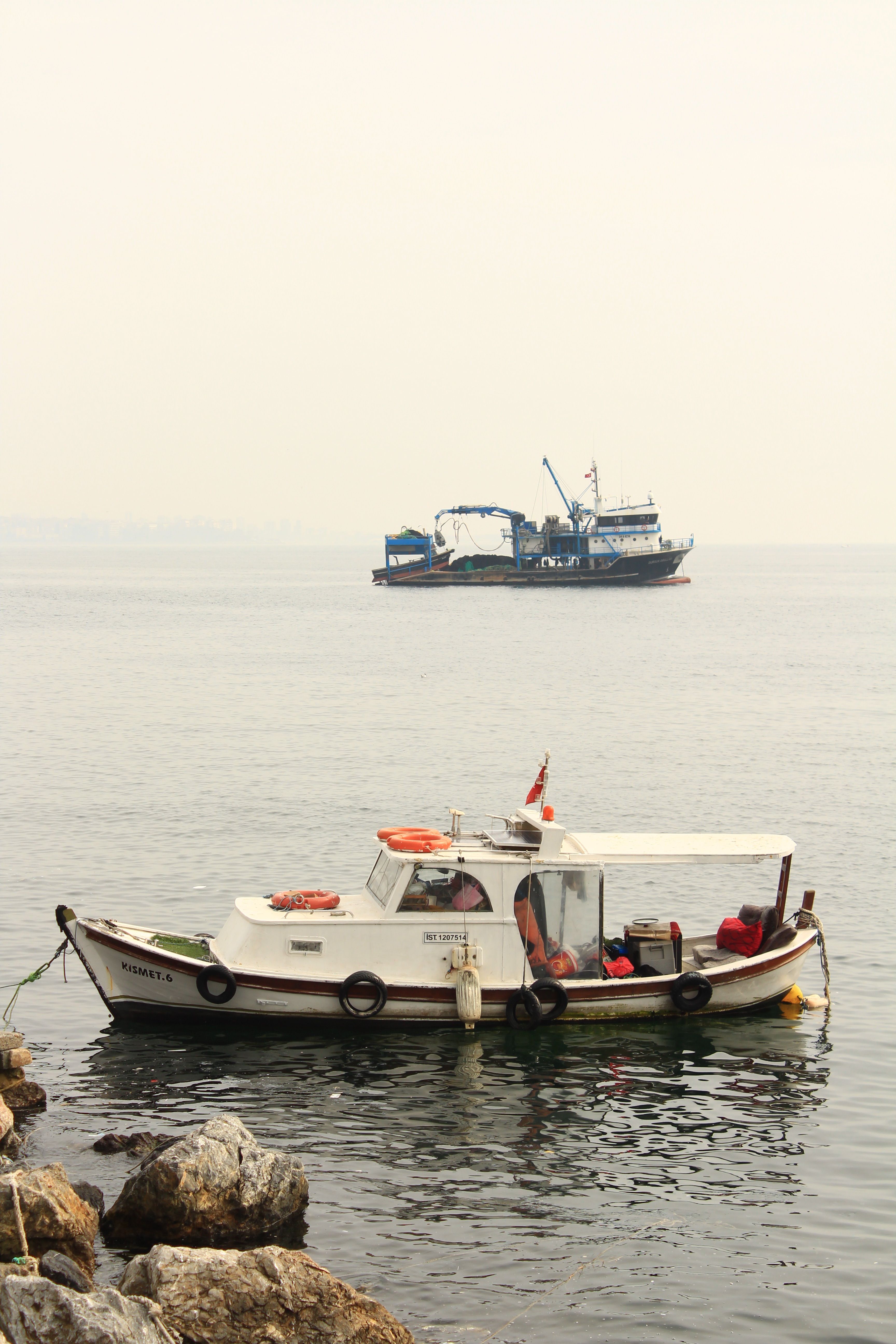 Image of moored fishing boats on a calm sea, evoking a peaceful marine atmosphere.