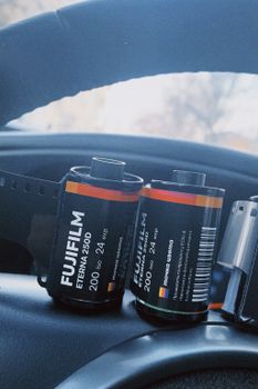 Close-up shot of Fujifilm ETERNA 250D film rolls resting on a car dashboard. Captured in New York, NY.