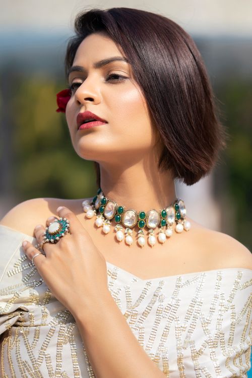 Free Beautiful woman posing gracefully with statement jewelry in natural sunlight. Stock Photo