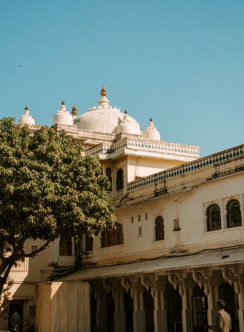 Captivating view of a traditional Indian palace with a white dome under a clear blue sky.