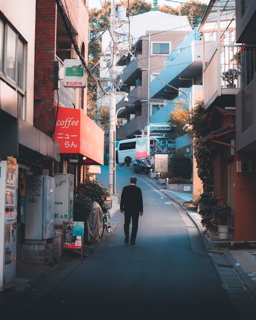 Back View of a Man Walking in an Residential District