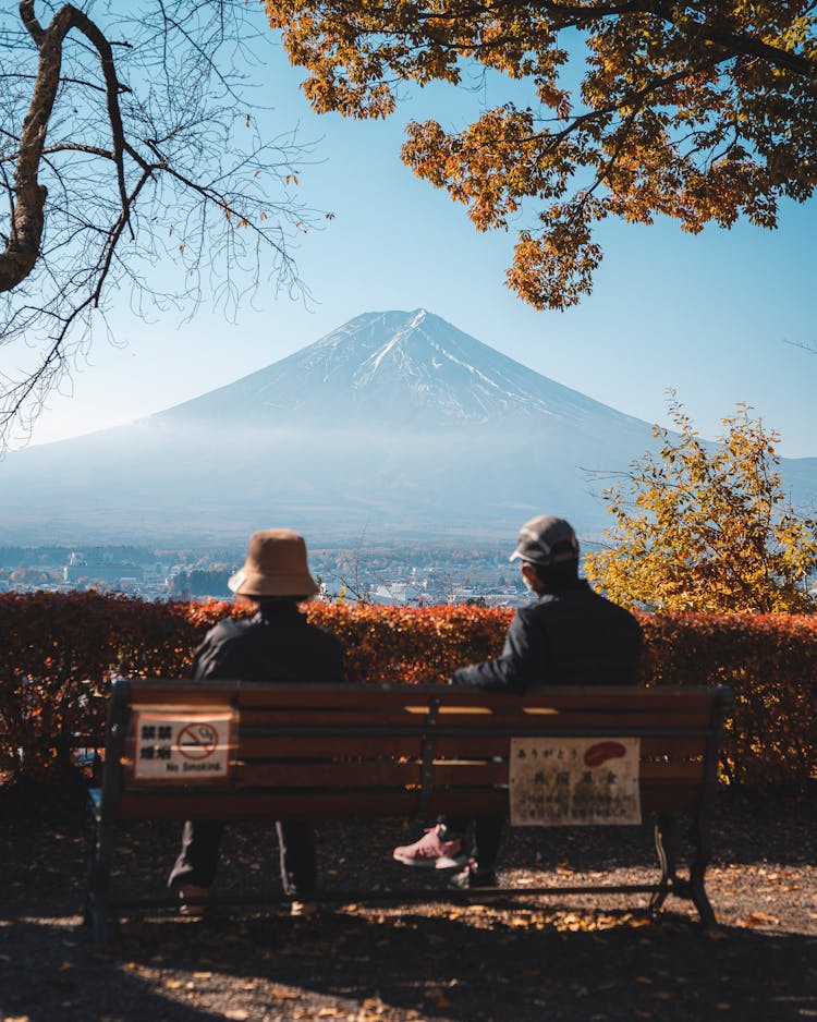 Couple Sitting On A Bench And Looking At Mount Fuji 