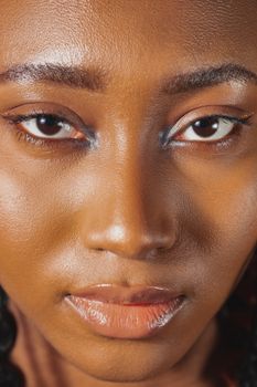 A vibrant close-up portrait of a confident young African American woman with striking features.
