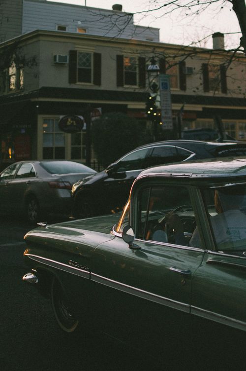 Free A vintage car parked on a city street in Philadelphia during sunset. Stock Photo