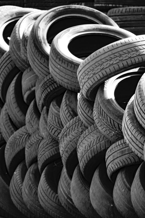 Free Artistic black and white image of a stack of used tires outdoors. Perfect for recycling concepts. Stock Photo