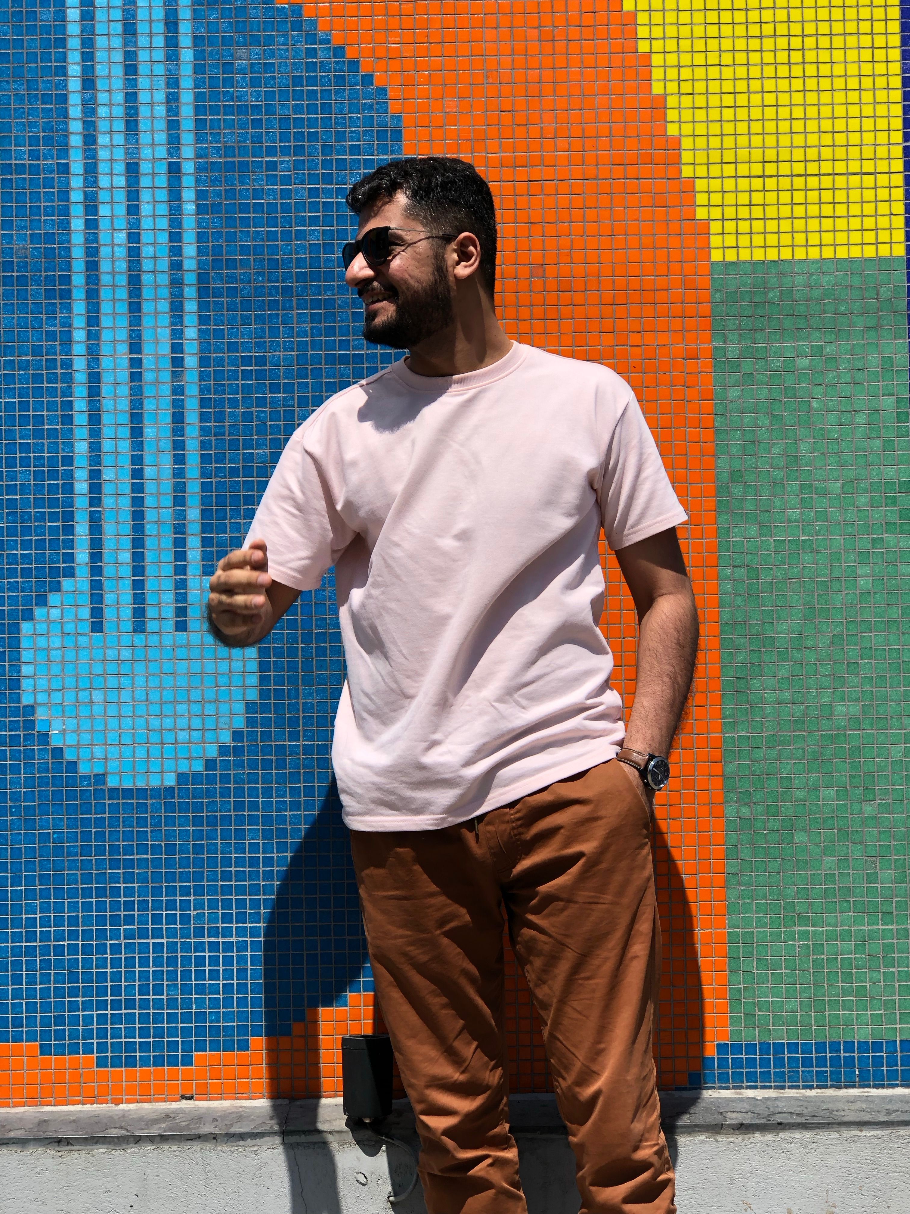 Man in Orange Shirt and Sunglasses Posing by Water · Free Stock Photo