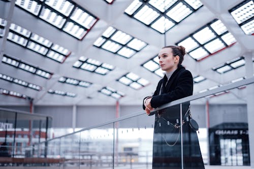 Woman in a Black Coat at an Airport Terminal 